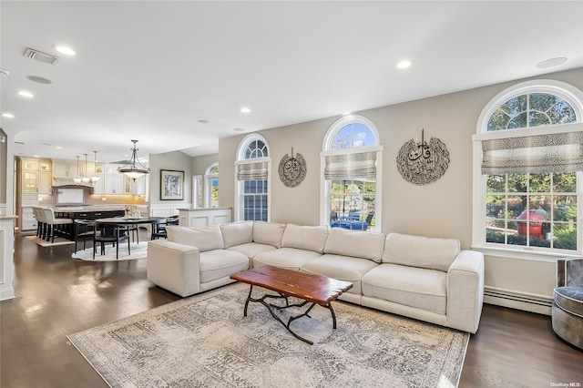 living room featuring dark hardwood / wood-style flooring and a baseboard heating unit