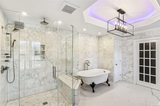 bathroom with a raised ceiling, ornamental molding, shower with separate bathtub, tile walls, and a notable chandelier