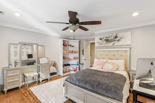 bedroom with hardwood / wood-style floors, ceiling fan, and crown molding