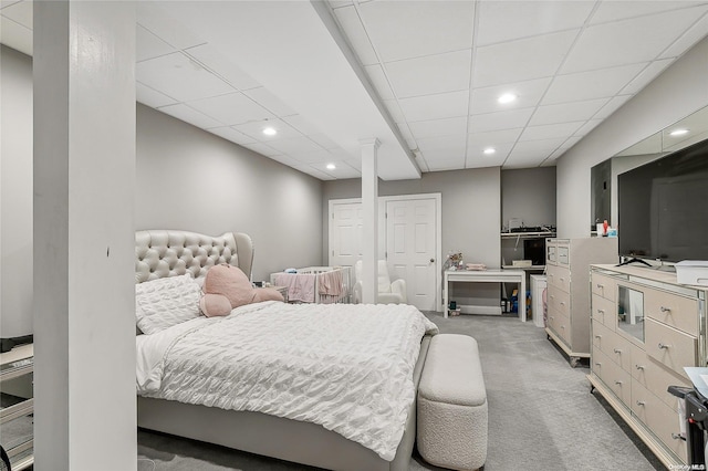 bedroom featuring a drop ceiling and carpet floors