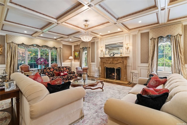 living room featuring a fireplace, an inviting chandelier, a wealth of natural light, and coffered ceiling