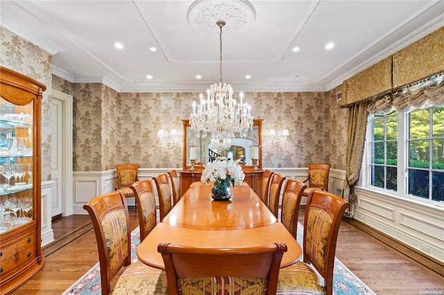 dining area featuring crown molding, light hardwood / wood-style flooring, and a chandelier