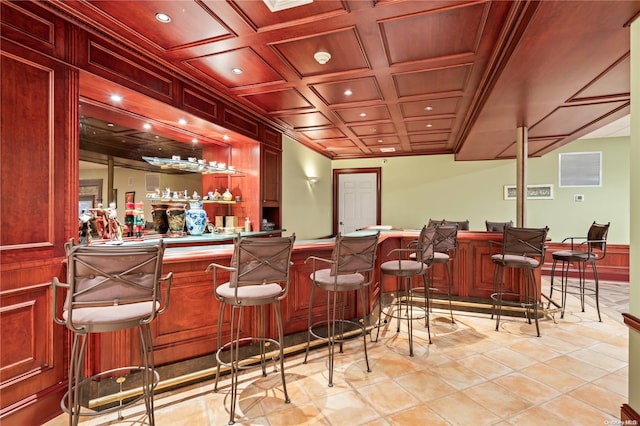 bar with light tile patterned flooring, coffered ceiling, and ornamental molding