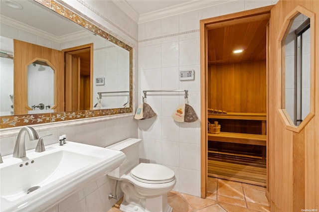 bathroom featuring sink, crown molding, tile patterned flooring, toilet, and tile walls