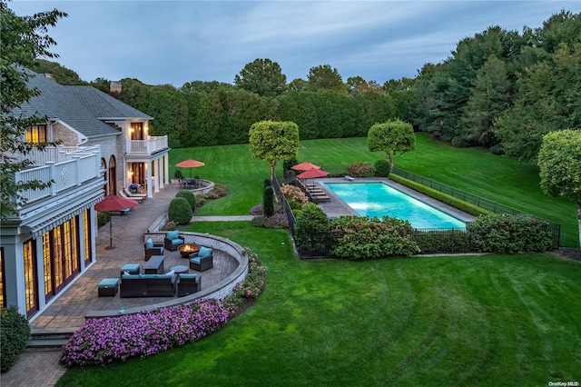 view of swimming pool featuring a patio area, a yard, and an outdoor living space with a fire pit