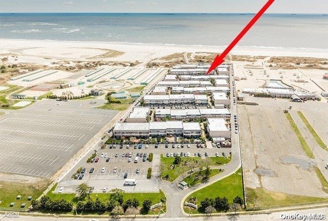 drone / aerial view featuring a water view and a view of the beach