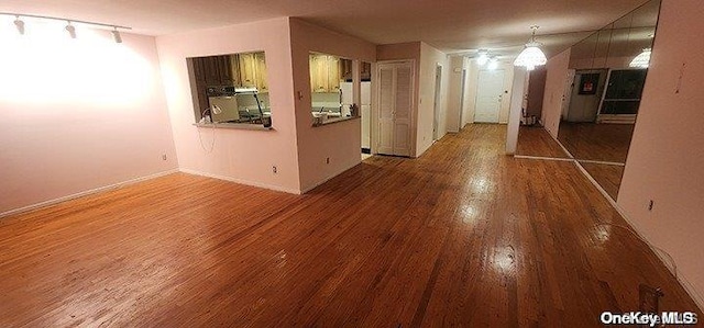 empty room with wood-type flooring and rail lighting