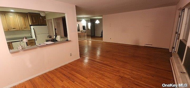 kitchen featuring dark hardwood / wood-style floors, white refrigerator, and baseboard heating