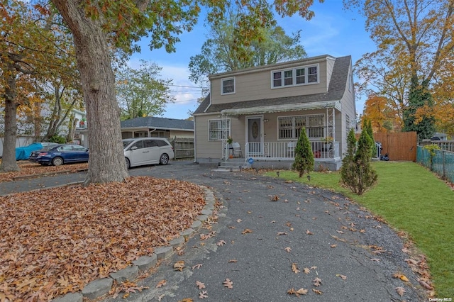 view of property with covered porch and a front yard