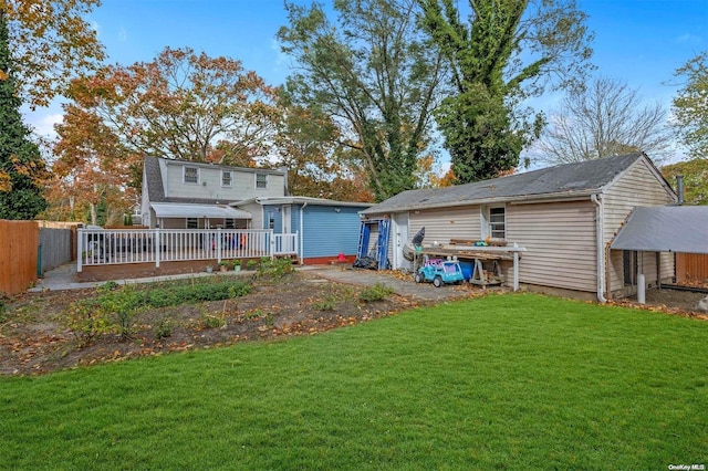 back of house with a lawn and a deck