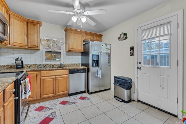 kitchen with sink, ceiling fan, tasteful backsplash, light stone counters, and stainless steel appliances