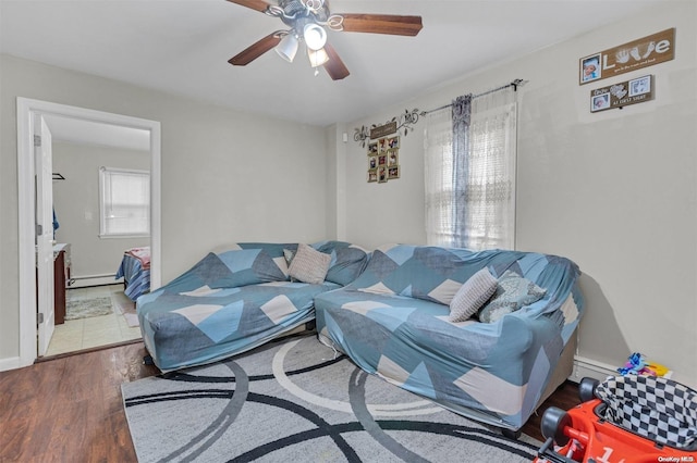 living room with ceiling fan, a baseboard radiator, and hardwood / wood-style flooring