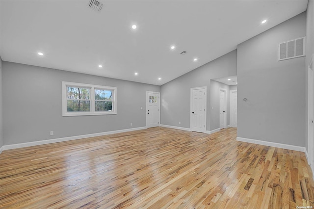 unfurnished living room featuring high vaulted ceiling and light wood-type flooring