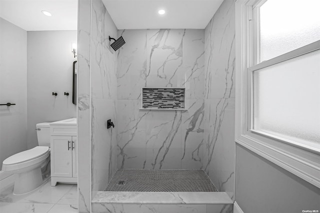 bathroom featuring vanity, toilet, and a tile shower