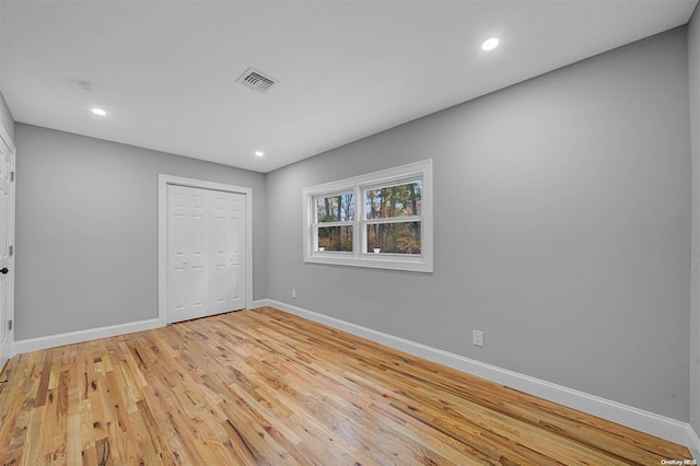 unfurnished bedroom featuring a closet and light wood-type flooring