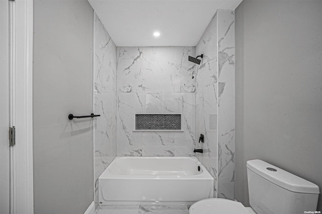 bathroom featuring toilet and tiled shower / bath