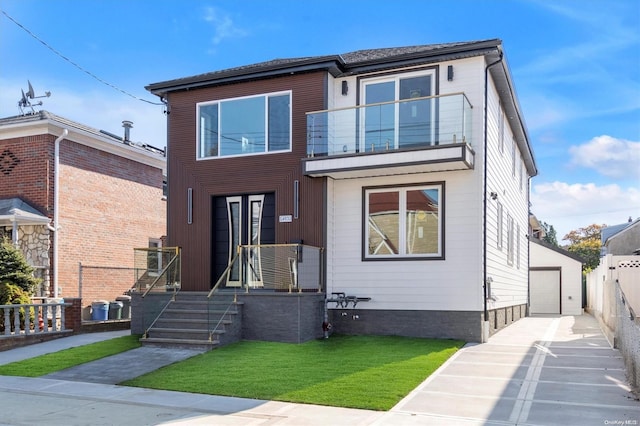 view of front facade featuring a balcony, a garage, a front lawn, and an outdoor structure