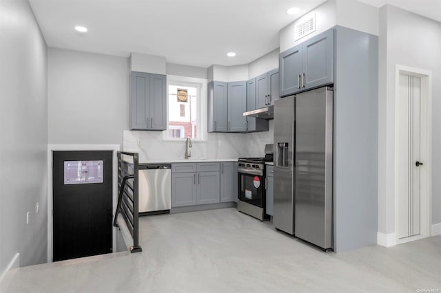 kitchen with gray cabinetry, sink, stainless steel appliances, and tasteful backsplash