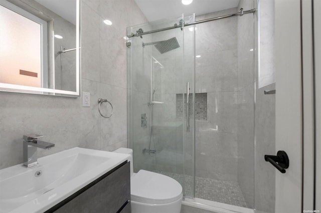 bathroom featuring vanity, toilet, and an enclosed shower