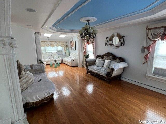 interior space featuring a chandelier, hardwood / wood-style flooring, plenty of natural light, and a tray ceiling