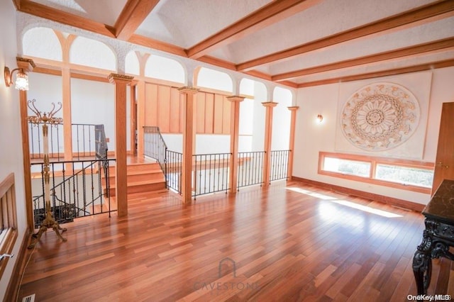 unfurnished living room featuring beamed ceiling and wood-type flooring