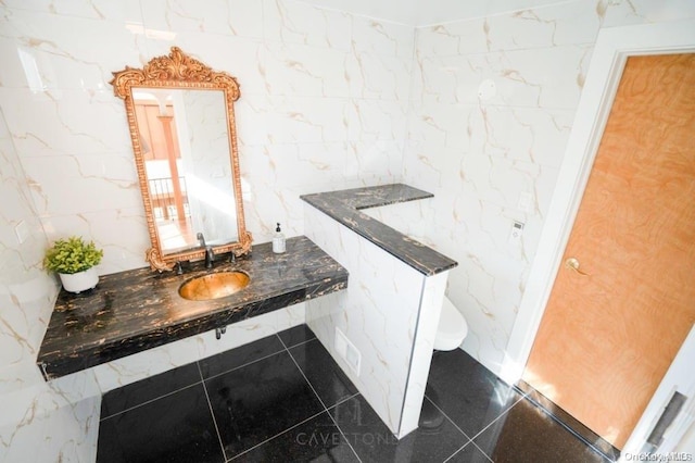 bathroom with sink, tile walls, and toilet