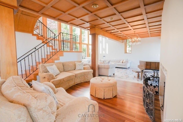 living room with a chandelier, hardwood / wood-style floors, and coffered ceiling