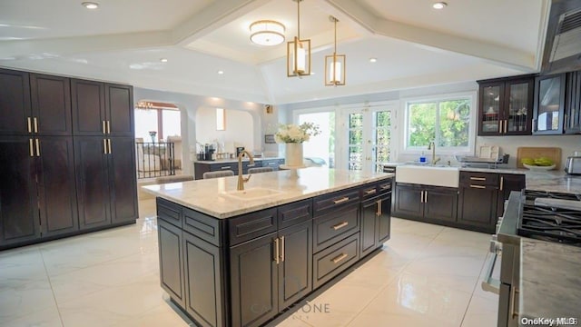 kitchen featuring dark brown cabinetry, sink, a center island, and pendant lighting