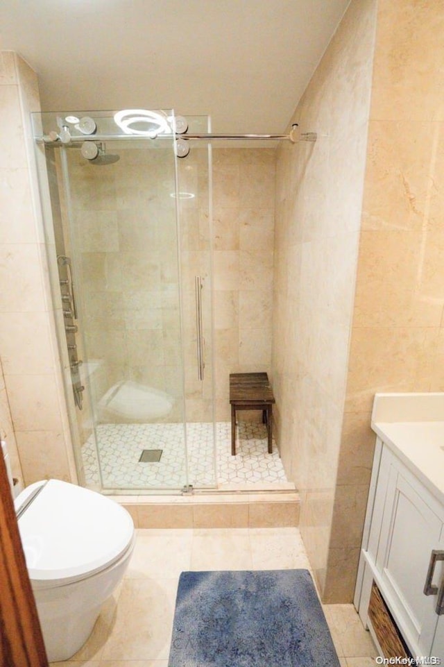 bathroom with tile patterned flooring, vanity, and walk in shower