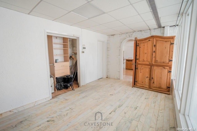 unfurnished room featuring a paneled ceiling and light hardwood / wood-style flooring