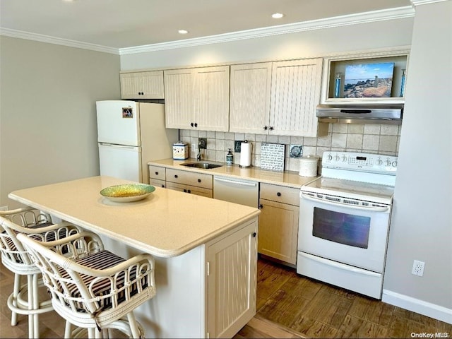 kitchen with white appliances, dark hardwood / wood-style floors, a kitchen island, and a breakfast bar area