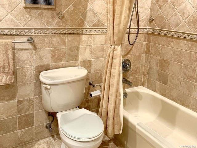 bathroom featuring toilet, tile walls, and shower / bath combo with shower curtain