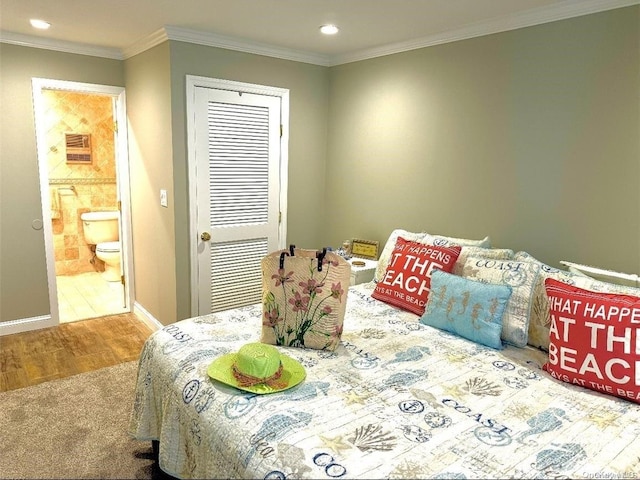 bedroom featuring wood-type flooring, ensuite bath, a closet, and ornamental molding