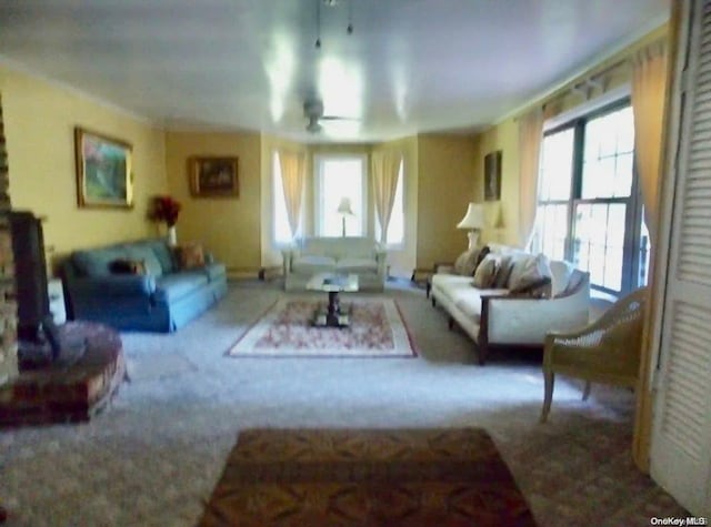 living room with a wealth of natural light, carpet, and ceiling fan