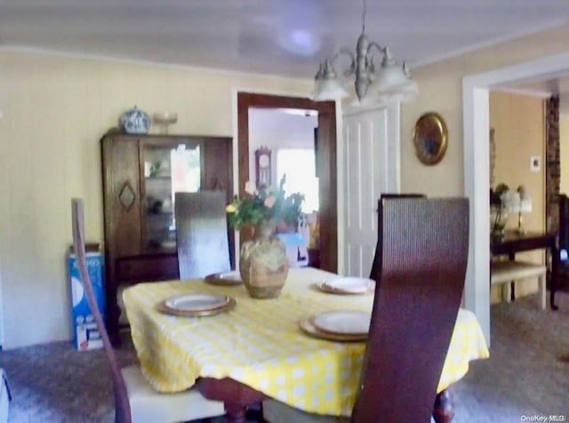 dining space featuring crown molding and a chandelier