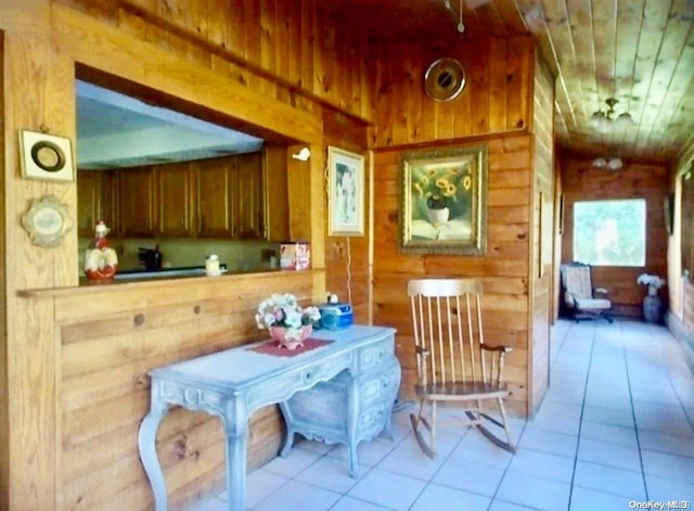 interior space with wooden walls, light tile patterned flooring, and wooden ceiling