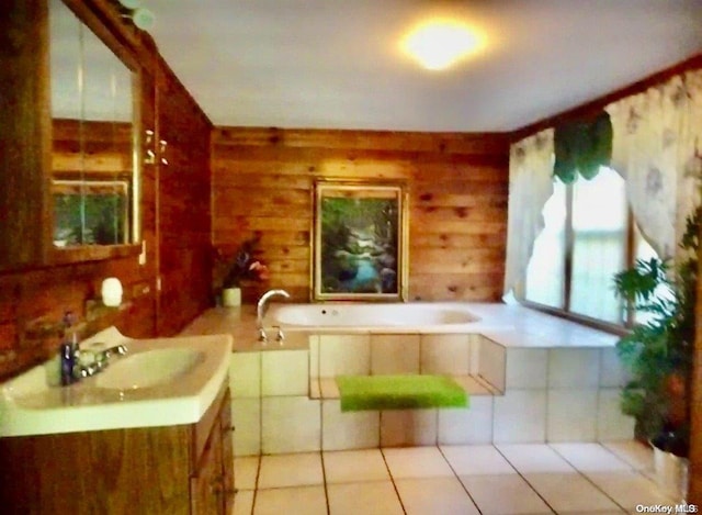 bathroom with tile patterned floors, wood walls, a bathtub, and vanity