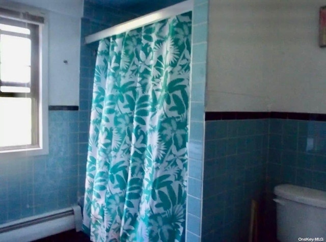 bathroom with a shower with shower curtain, toilet, and a baseboard heating unit