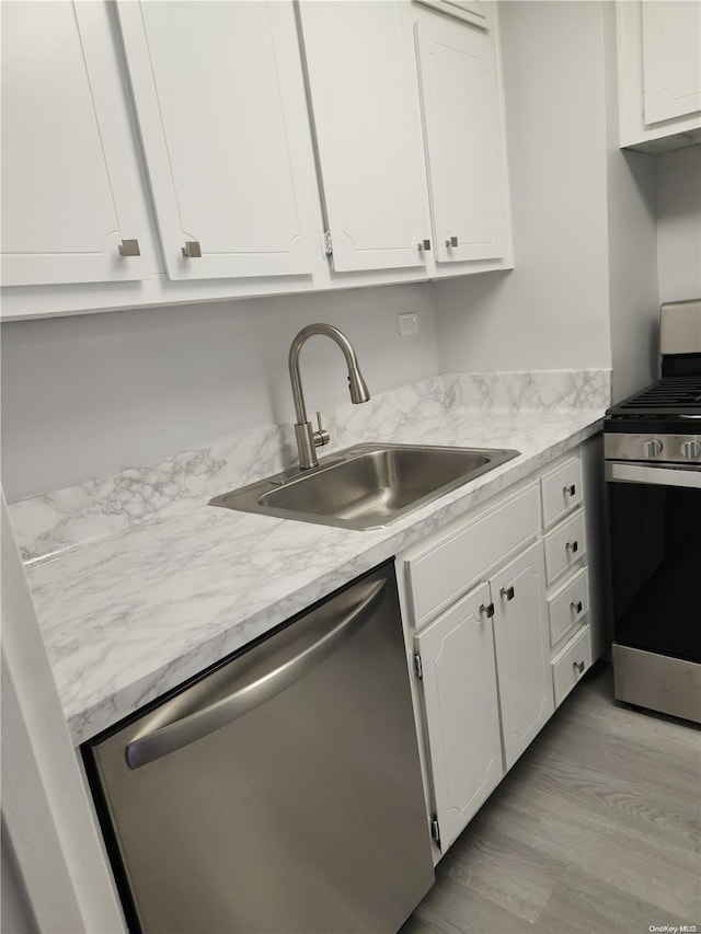 kitchen featuring white cabinetry, sink, light wood-type flooring, and appliances with stainless steel finishes