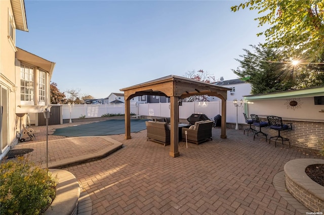 view of patio with a gazebo, a covered pool, and an outdoor hangout area