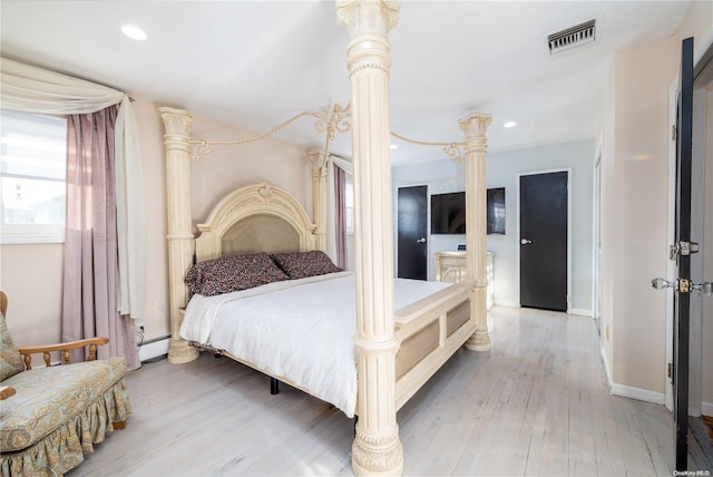 bedroom with light wood-type flooring and a baseboard radiator