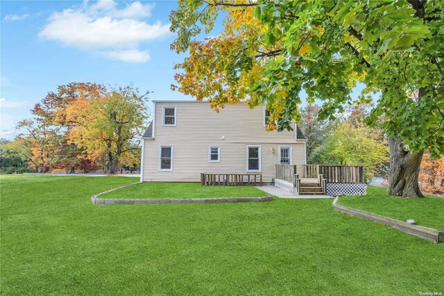 back of property featuring a yard and a deck