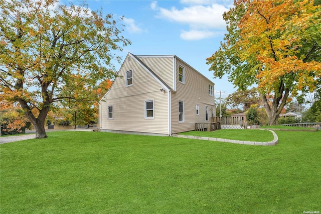 view of home's exterior featuring a deck and a yard