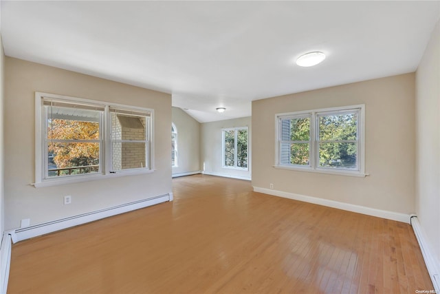 spare room with baseboard heating and light hardwood / wood-style flooring