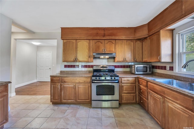 kitchen with appliances with stainless steel finishes, backsplash, and sink