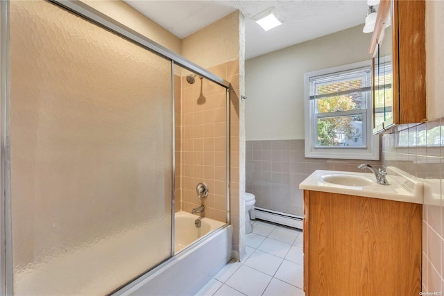 full bathroom with tile patterned floors, vanity, baseboard heating, tile walls, and toilet