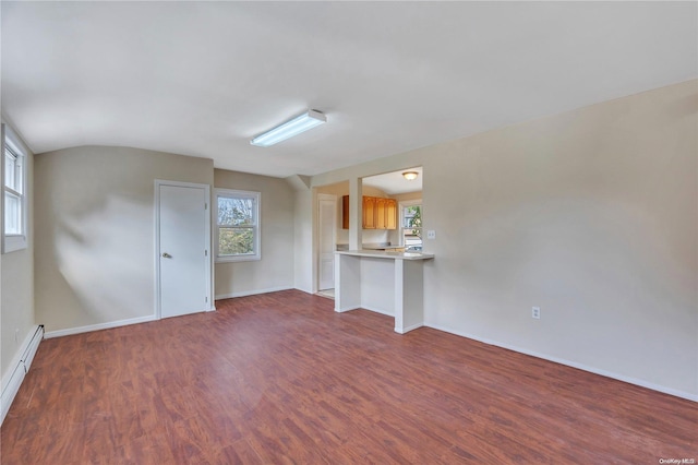 unfurnished living room with baseboard heating and hardwood / wood-style flooring