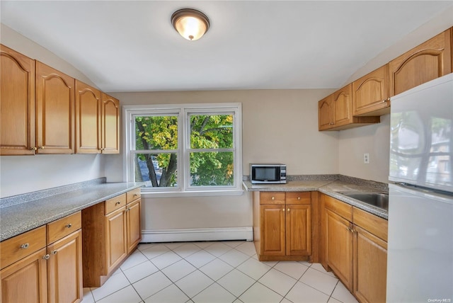 kitchen featuring white refrigerator, light tile patterned flooring, sink, and a baseboard radiator