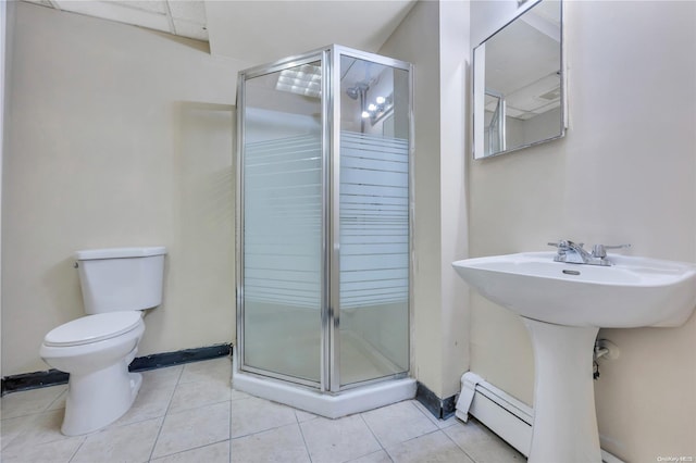 bathroom featuring tile patterned floors, a shower with door, a baseboard heating unit, and toilet