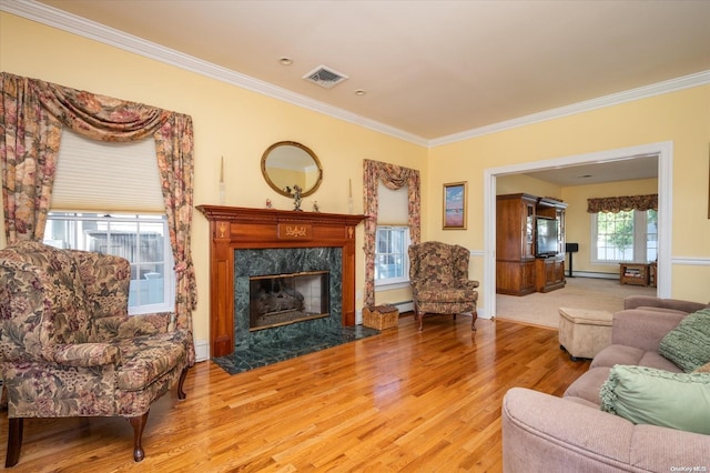 living room featuring hardwood / wood-style flooring, a high end fireplace, a baseboard radiator, and ornamental molding